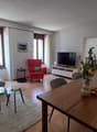Dining room: table with chairs, living room visible in the background, TV, lamp