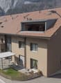3 story house, brown roof, multiple balconies, windows, street view