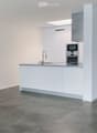 Modern kitchen with white cabinets, stainless steel appliances, and a central island with a sink and faucet.