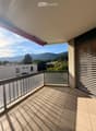 Balcony with tiled floor, glass railing, and scenic mountain view.