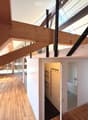 Open hallway with wooden flooring, white walls, and visible rooms including a bathroom with a bathtub and a closet with hanging space.