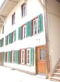 two story house, wooden door, wooden stairs, wooden railing, green shutters, white walls, windows