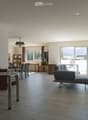 Open-plan living and dining area with modern furniture, large windows, and a view of the landscape.