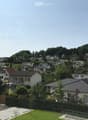 Residential neighborhood with multiple houses, surrounded by greenery and trees, with a clear view of the surrounding landscape.