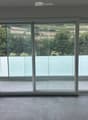 Empty room with large sliding glass doors leading to a balcony, tiled floor, and modern white frame.