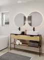 Modern bathroom with a bathtub, double sink vanity, large mirrors, and a small wooden stool holding toiletries.