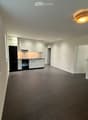 Empty kitchen with white cabinets, black appliances, and dark tiled flooring.