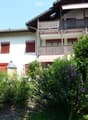 2 story house, white exterior, red shutters, balcony, red awning, garden, number 4