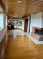 Open-plan living and dining area with wooden flooring, fireplace, and integrated kitchen featuring cabinets, a dishwasher, and a sink.