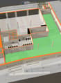 3D floor plan of a multi-level building with labeled rooms, including a garage, garden, and commercial space. Dimensions and room labels are visible.