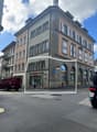 Multi-story building with classic architecture, arched entrance, and multiple windows with shutters.