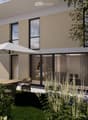 Modern house exterior with large windows, sliding glass doors, outdoor patio furniture, and lush garden with colorful flowers and greenery.