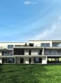 Modern two-story house with large windows, balconies, and a flat roof, surrounded by a green lawn and trees.