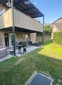 Garden with a hot tub, outdoor seating area, and a covered balcony with a view of the house.