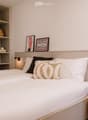 Modern bedroom with a neatly made bed, nightstand, and decorative items on shelves and walls.