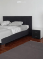 Modern bedroom with a dark wooden bed, white bedding, a nightstand, a wardrobe, and a grey rug on the floor.