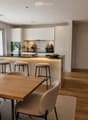 Open-plan living and dining area with modern furniture, pendant lights, and a sleek kitchen island.