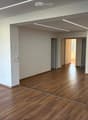 Empty room with wooden flooring, white walls, and recessed lighting. No furniture or equipment present.