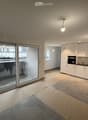 living room, open floor plan, kitchen, large sliding glass door, balcony, white cabinets, tiled floor
