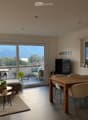 Modern living and dining area with a view, featuring a grey sectional sofa, coffee table, dining table with chairs, and a television.
