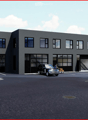 Modern industrial-style building with large garage doors, multiple windows, and a paved parking area.