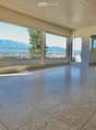 Empty room with large windows and a view of mountains, featuring a tiled floor and a fireplace insert.