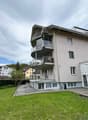 3 story building, balconies, large windows, garden, tennis court