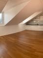 Spacious attic apartment with vaulted ceilings, hardwood floors, and a modern kitchen with built-in appliances including a dishwasher.
