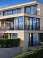 Exklusive Seesicht: Moderne Architektur mit Naturstein und Panoramafenstern im Lakeside Residenz-Ensemble