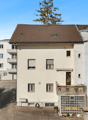 white apartment building, balconies, brown roof, multiple windows, chimneys