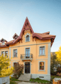 2 story house, yellow exterior, red roof, balcony, multiple windows, front door, steps leading to entrance