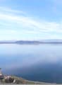 large lake, distant mountains, buildings on the shore