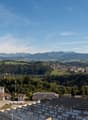 Aerial view of the city with many buildings, greenery, and mountains