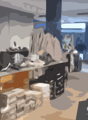 Clothing store interior with shelves of clothes, display table, and natural light