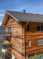 wooden exterior, multiple balconies, gray roof, mountain view