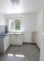 White cabinets, gray tiled floor, window with radiator, stainless steel sink, white ceiling light