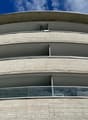 modern design, multiple balconies, curved walls, concrete and glass