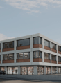 A modern, multi-story commercial building with a mix of glass and brick exterior. The building has multiple floors and appears to have retail or office spaces on the ground level. There is a parking area visible in front of the building.