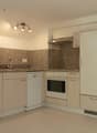 modern kitchen with white appliances, granite countertops, wooden cabinets, tiled floor