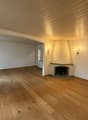 empty room, wooden floor, white walls, fireplace, wall lamps