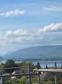 View of a lake and mountains from a balcony with construction scaffolding