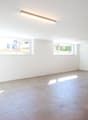 empty room, white walls, tiled floor, three windows, artificial lighting