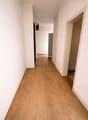 Empty hallway with wooden floor and white walls