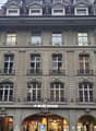 4 story building, multiple windows, balconies, 3 entrances, 1 with ALDI Suisse sign
