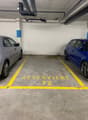 an underground parking garage with a gray and blue car parked in parking spot number 72, along with a blue car parked in parking spot number 73