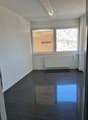 empty room, white walls, black floor, white radiator, window