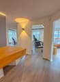 wooden desk, hardwood floor, white walls, 2 chairs, window with view