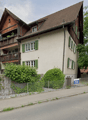 3 story house, brown roof, green shutters, balconies, garden, fence