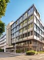 Modern office building with glass facade, multiple floors, and a corner entrance.