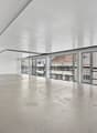 Spacious, clean, white walls, concrete floor, open doors, glass walls, balconies